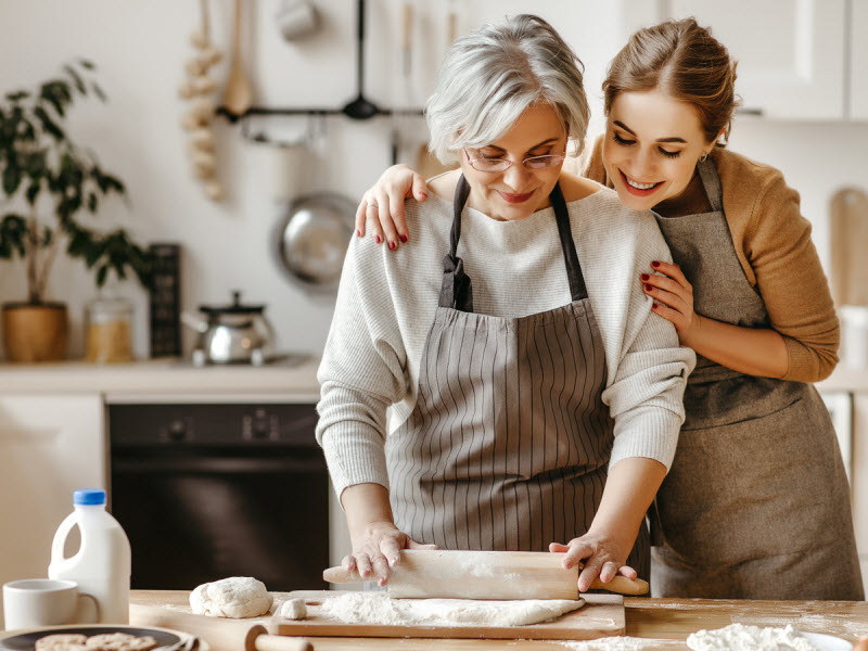 Happy mother and daughter baking at the kitchen