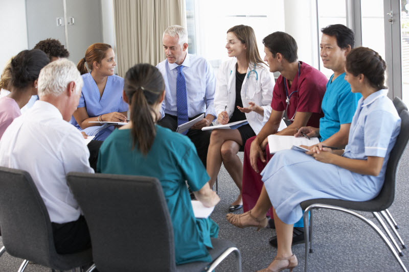 Medical Staff Seated In Circle At Case Meeting