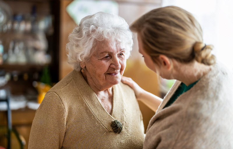 Health visitor talking to a senior woman during home visit