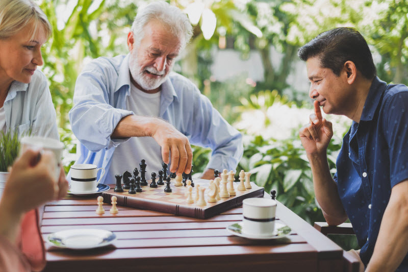 Senior old man playing chess game on chess board